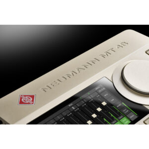 Neumann MT 48 audio interface close-up: silver finish, control dial, digital audio level display, engraved branding.