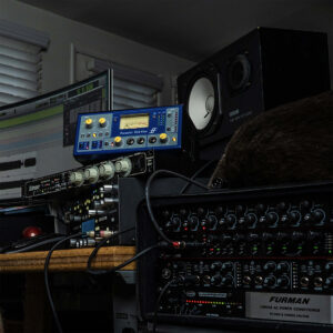 Home studio with Focusrite ISA One preamp, Furman power conditioner, rack gear, studio monitors, and audio editing screen.