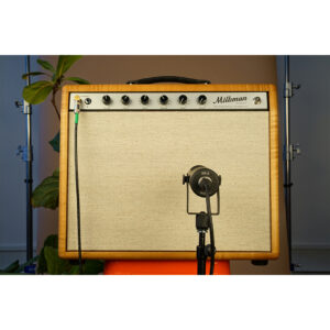 Milkman guitar amp, beige front with wood trim, on orange stool; Stager SR-5 mic and green cable; leafy plant in background.