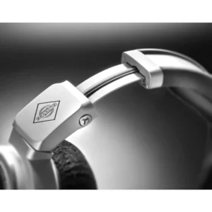 Close-up of the Neumann NDH 30 Open Box silver headphones, highlighting the adjustable headband with Neumann’s iconic logo and plush cushioned ear pad; set against a softly blurred gray and black background. Premium listening equipment available now at Providence Sound And Vision.