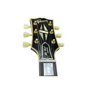 Gibson Custom 1957 Les Paul Reissue headstock, gold accents, white tuners, inlays on black; Gibson logo at top.