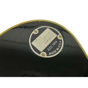 Metal plate on black Gibson Custom 1957 Les Paul Reissue, SN 71228, engraved EST. 1894, USA; gold-trim accents.