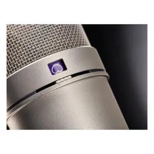 Open box Neumann U 87 Ai Set Z condenser microphone, silver finish, mesh grille, purple heart symbol, dark backdrop.