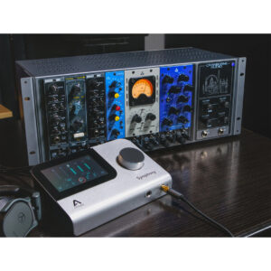 Cranborne 500ADAT rackmount processor with VU meter and interface sits on a dark table beside headphones.