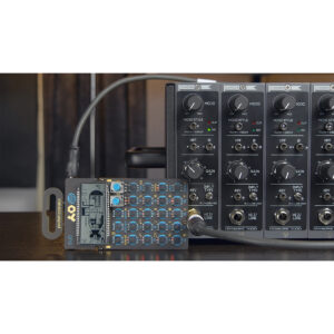 Cranborne Camden 500 mixer channels labeled MONO STYLE linked to a compact blue-button synthesizer on a dark desk.