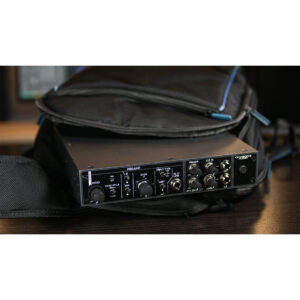 Cranborne Camden EC1 black audio preamp, partially out of black bag on dark wood, with knobs and ports visible.