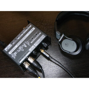 Cranborne N22H audio interface with connected cables sits on a dark wood desk next to black over-ear headphones.