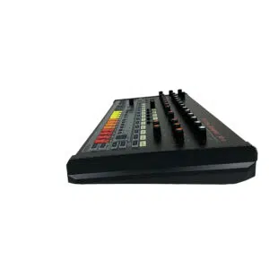 Preowned Behringer RD-8 drum machine, low side angle, colorful pads and knobs, white background.