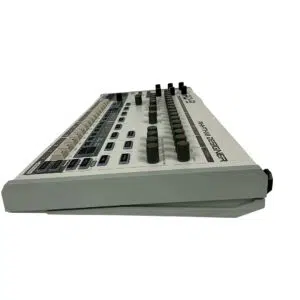 Behringer RD-9 Rhythm Designer, preowned, white/gray, side view with buttons, knobs, sliders; "RYTM DESIGNER" label visible.