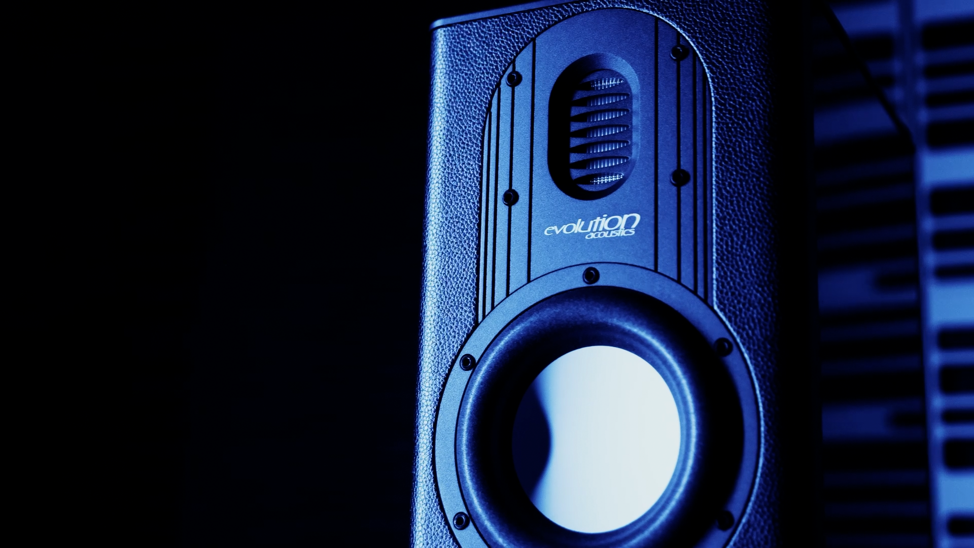Black Evolution Acoustics speaker with exposed woofer and tweeter, blue-lit, set against a dark backdrop.